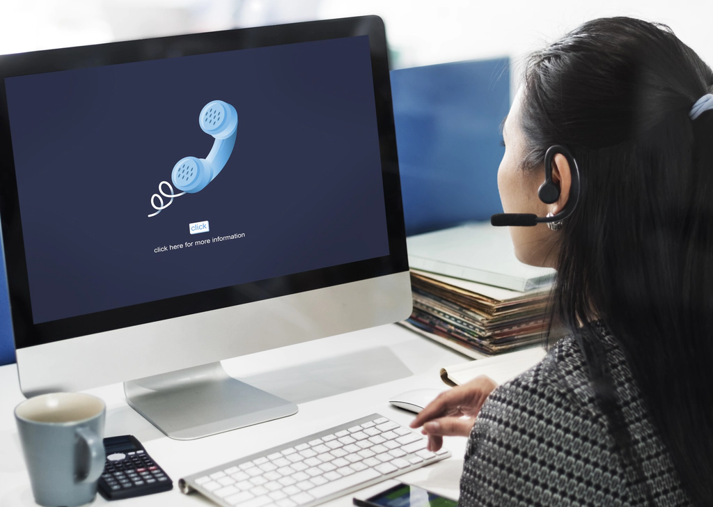 VOIP Systems And Solutions For Medium Business A woman working as a support staff looking up information about voice over IP phones.