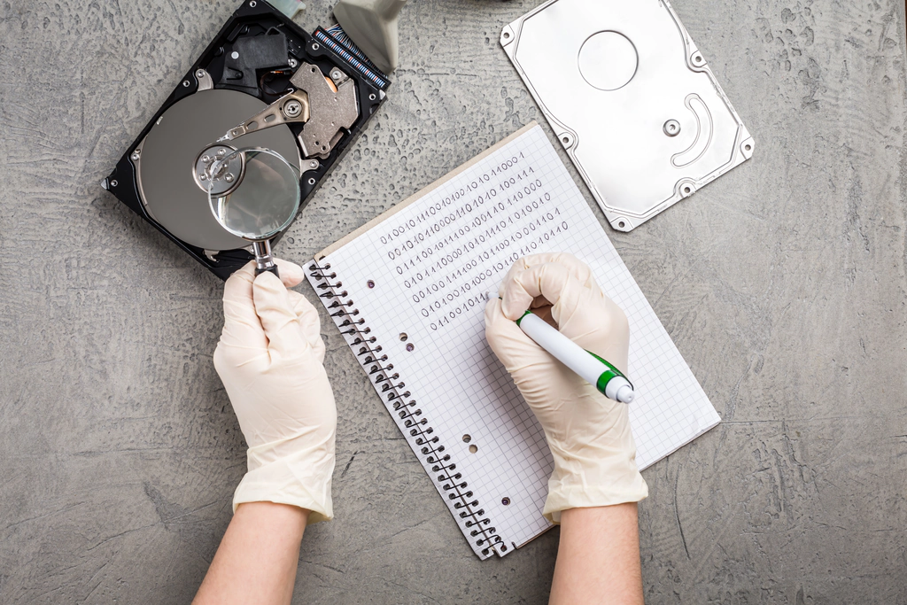 Backups, migrations, and more offered by Portland's local IT Support Firm Local business support engineer backing up a hard drive by hand by reading the bites off the hard drive