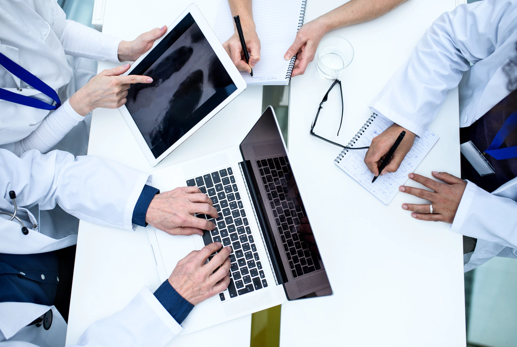 Medium size doctor's clinic with doctors discussing patient charts