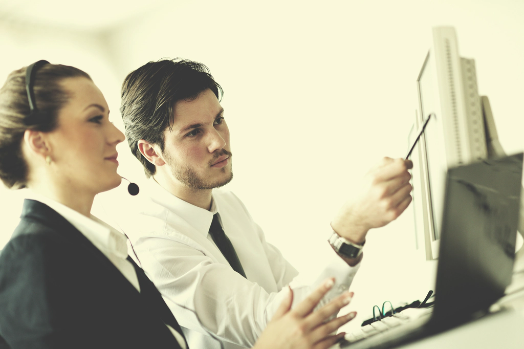 IT Support Firm delivering best in class managed it services A coworker helping explain managed it services on the computer screen