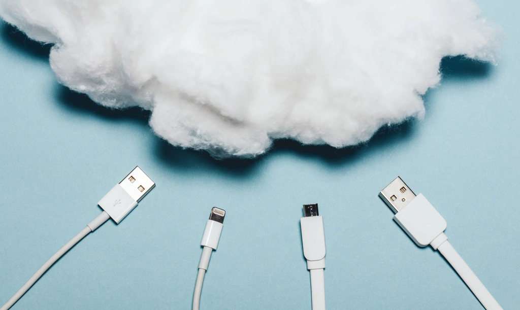 Small business technology solutions through managed it services Device cords moving towards a cloud made out of cotton shows the powerful tech solutions available for small business