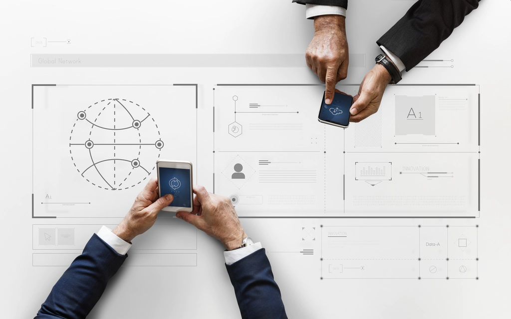 Small Business VoIP Providers Like Cisco Two business men using mobile phones on top of a work desk