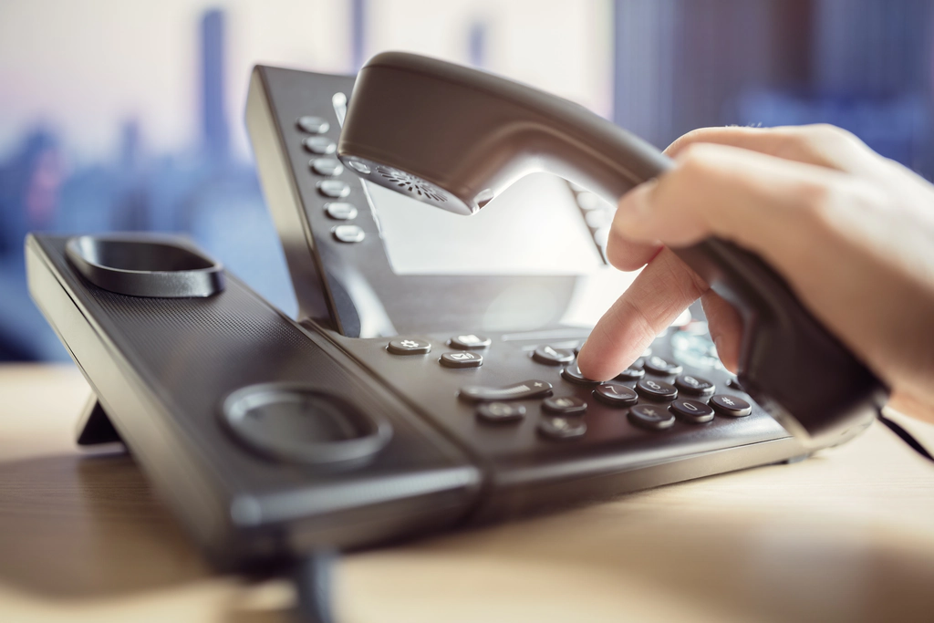 A hand dialing a voice over ip phone